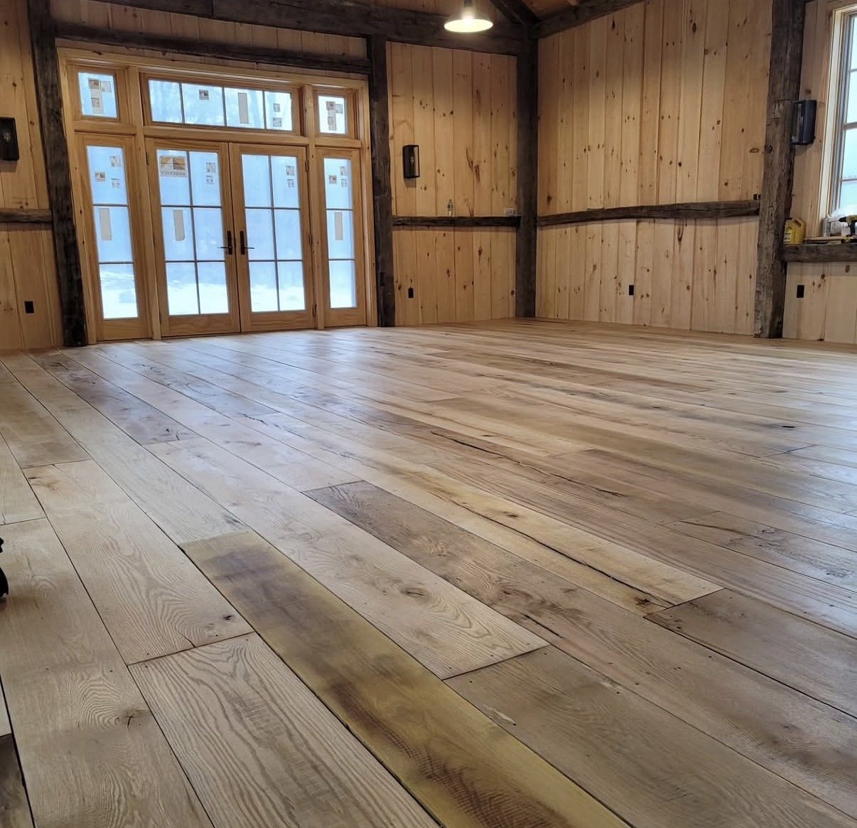 Wide-plank hardwood floor installed and sanded flat